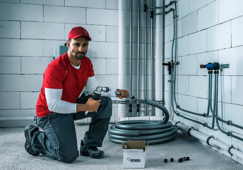 Professional plumber working on a commercial plumbing system in Lehi, UT