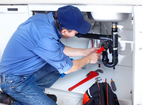 Residential plumbing expert installing new pipes in a bathroom in Lehi, Utah.